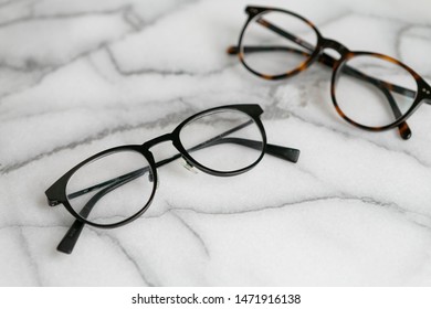 Black And Tortoise Shell Glasses On Marble Background, Copy Text Space