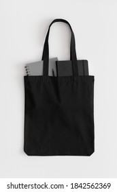 Black Tote Bag Mockup With Notebooks On A White Table.