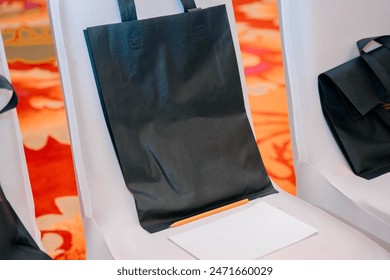 Black tote bag on white chair - Powered by Shutterstock