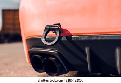 Black tow hook on the rear bumper of a pink car