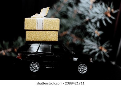 black toy car carrying gifts jewelry. Christmas decorations. The concept of Christmas mood and preparation for the celebration. Discounts present. Black Friday. 2024. Seasonal sale, big discounts