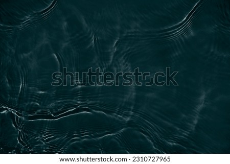 Black transparent clear calm water surface texture with ripples, splashes Abstract nature background. Dark grey water waves in sunlight Copy space top view Cosmetic moisturizer micellar toner emulsion