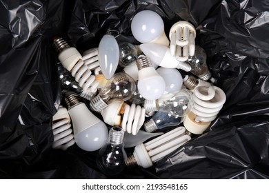 The black trash bag contains a lot of old energy-saving fluorescent lamps, used incandescent lamps for recycling.View from above. Hazardous and toxic waste