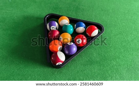 A black triangular tray with nine balls on it. The balls are numbered 1 through 9.