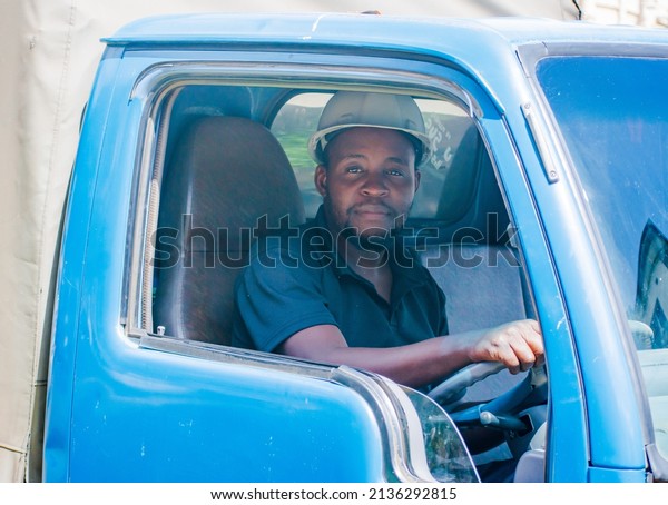 black truck driver\
smiling wearing a helmet