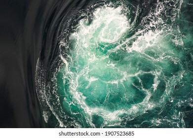 Black and turquoise swirling water of the Saltstraumen Maelstrom in Bodo, Norway. Saltstraumen has one of the strongest tidal currents in the world - Shutterstock ID 1907523685