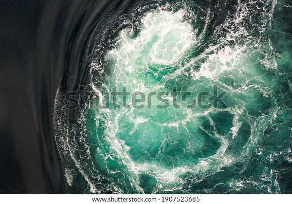 Black and turquoise swirling water of the\
Saltstraumen Maelstrom in Bodo, Norway. Saltstraumen has one of the\
strongest tidal currents in the\
world