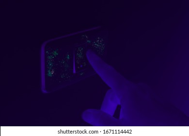 Black UV light exposing germs and bacteria on hand touching lighting switch - Ultraviolet blacklight shows hidden harmful infectious disease - Corona virus, hygiene, sickness and covid-19 concept