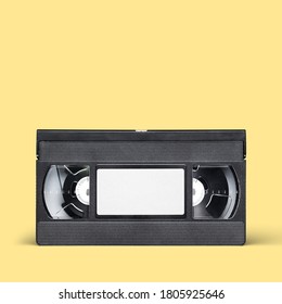 Black VHS Video Tape Cassette With Blank Label On Yellow Background