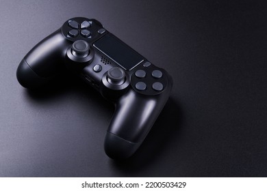 Black video game controller, joystick for game console isolated on black background. Gamer control device close-up