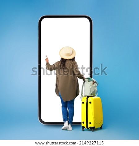 Black View Of Black Lady Using Big Smartphone Buying Travel Tickets Online Standing Near Huge Phone And Touching Blank Touchscreen On Blue Studio Background. Full Length, Square