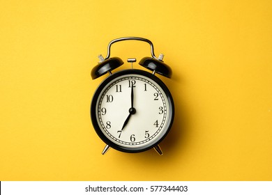 black vintage alarm clock on yellow color background - Shutterstock ID 577344403