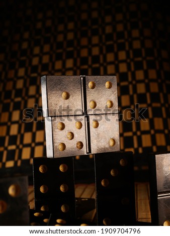 Black vintage dominoes on a black background, selective focus. WB photo.