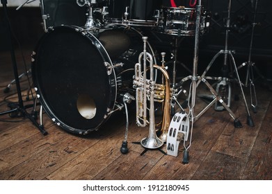 A Black Vintage Drum Kit And A Microphone Stand Are On Stage And Next To Them Are Two Trumpets (alto And Bass) And A White Tambourine. The Concept Of A Live Concert Of A Jazz Band.