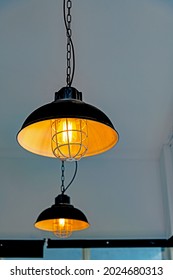 Black Vintage Of Black Light Bulb Lamp Hanging From The Ceiling. Concept Of Vintage Restaurant And Cafe Decoration. Taken With Selective Focus Area.