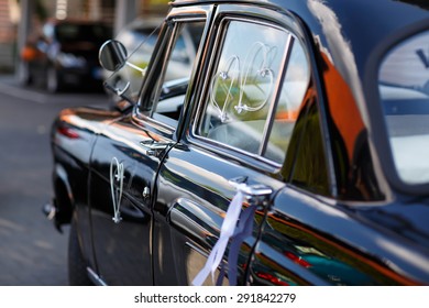 black vintage wedding car decorated with white bows and hearts - Shutterstock ID 291842279