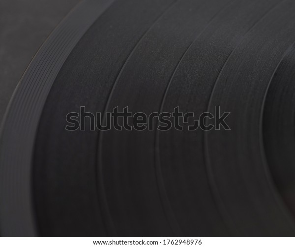 Black vinyl plate with soundtracks on it,\
selective focus,\
close-up.\
