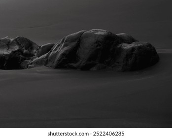 Black volcanic sand with dark basalt rocks on the Atlantic Ocean coast, atmospheric backdrop with natural elements at the foot of the volcano near the water. - Powered by Shutterstock