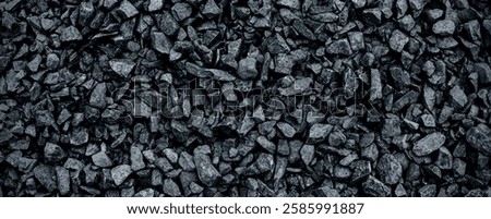 Black volcanic stone. Surface of basalt or granite close-up. Dark rough and textured rock. Dark toned background .