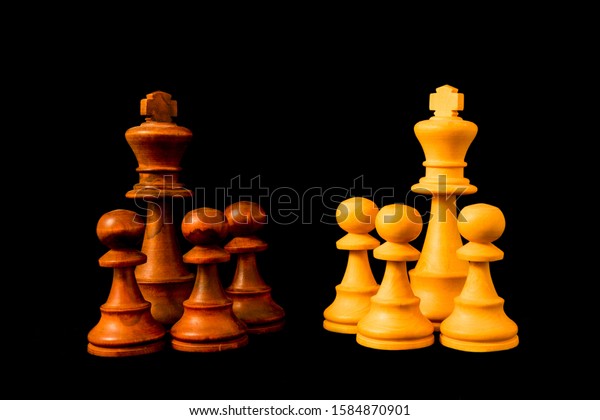 Black vs White. Two hostile groups opposing\
each other. Divide et impera (Divide and Rule) concept. Standard\
chess wooden piece on black\
background