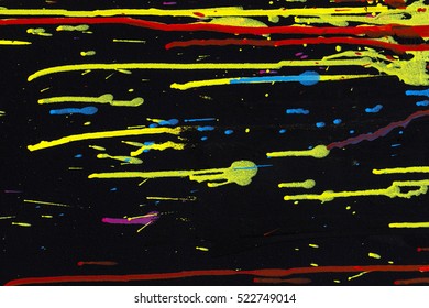 Black wall sprayed with various vivid colors of paint.