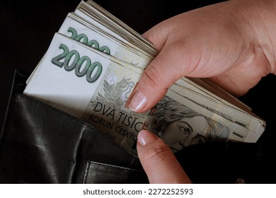 In a black wallet are bills of two thousand crowns, Czech money.