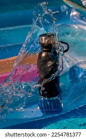 A black water bottle on an inflatable mattress is washed by a wave - Shutterstock ID 2254781377