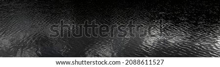 Black water in the ocean, black and white glare on the water. Shimmer on the water