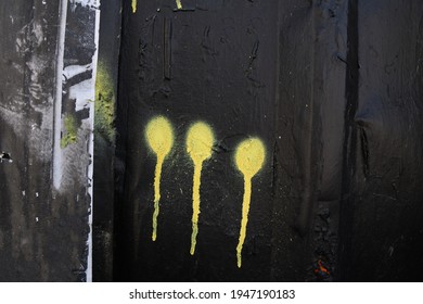 Black Weathered Abandoned Street Alley Exterior Wall With Yellow Running Graffiti Spray Paint Drips 