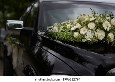 A Black Wedding Car Decorated With White Roses, Bridal Bouquet, Just Married