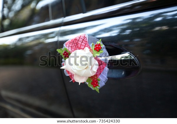 Black wedding car with the decoration on the\
handle closeup