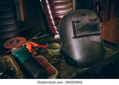 Black Welding Mask On Workshop Table With Tools In Vintage Dark Style, Copy Space