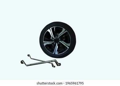 Black Wheels With Black Aluminum Mac Placed On A White Background, Waiting To Be Repaired. In Front There Are Tools Such As 2 Screwdrivers To Wait For The Mechanic To Repair.