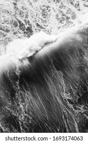 Black and white aerial view of a breaking wave, on a big swell day in france, lots of whitewater and energy