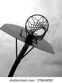  Black And White Aged And Worn Vintage Photo Of Outdoors Basketball Hoop With Bright Sun Flare                             