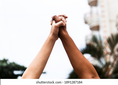 a black and a white arm together holding hands extended upwards. Black lives matter. Symbolic picture showing that we are stronger together.  