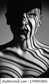 Black and white art fashion portrait of beautiful woman with a beam of light on her face. Fashion art studio portrait