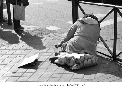 black and white artistic photograph of beggar asking for alms in a central street of Madrid, Spain, - Shutterstock ID 1656930577