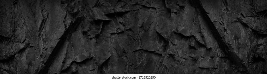 Black and white background. Copy space. Dark stone grunge background. Mountain texture. Close-up. Web banner. Wide. Volumetric rock texture. Panoramic.