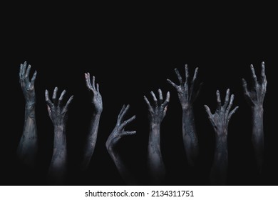 black and white background for Halloween night of many scary and creepy zombie hands raising from darkness