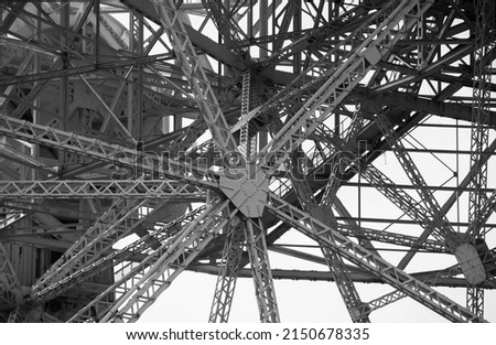 Black and white background of metal structure with struts, bars, rivets and bolts