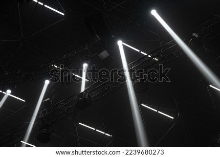 Black and white background with spot light. Moving head light with dark light truss