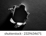 Black and white background of torn paper with hole