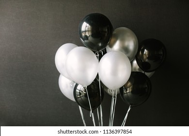 Black and white balloons on a dark black background. Celebration concept / White and black balloons on a dark black background for a holiday, birthday or other holiday. Photo for posters or postcards. - Powered by Shutterstock