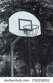 Black And White Basketball Backboard And Basket In  Eastern Euorope With A Socialist Block Of Flats In The Background, Residential Area, No People, Empty And Closed Courts During Lockdown