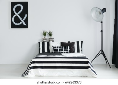 Black And White Bedroom With Double Bed And Floor Lamp