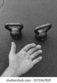 Black and White BnW Calloused hand with two 20 lb kettle bells. Jocko style photo.