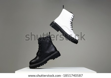 Black and white boots in the air. fashion shoes still life. stylish photo in the studio