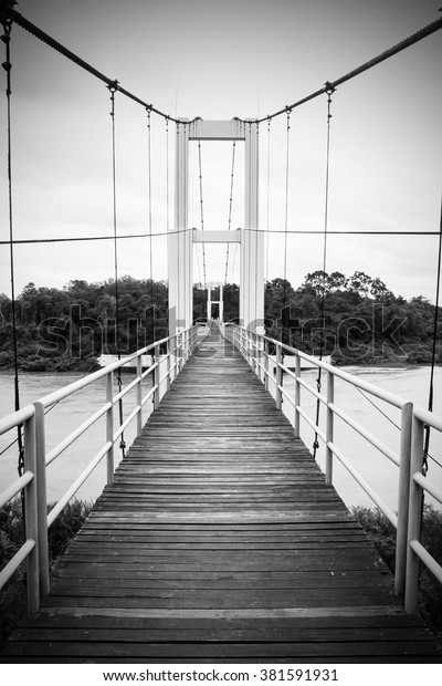 Black and white bridge with rope for walking over the\
river Thailand 