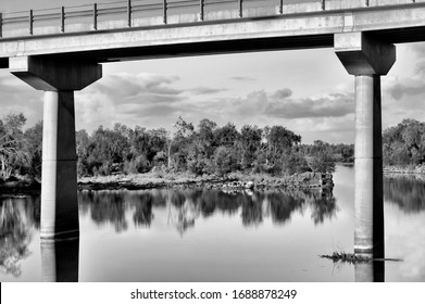 Black And White Capture Of A Long Concrete Bridge, Shot Taken Below The Bridge On The River,   
 Looking Up At The Bottom Of The Bridge, Creative Perspective.
Outback Australia.